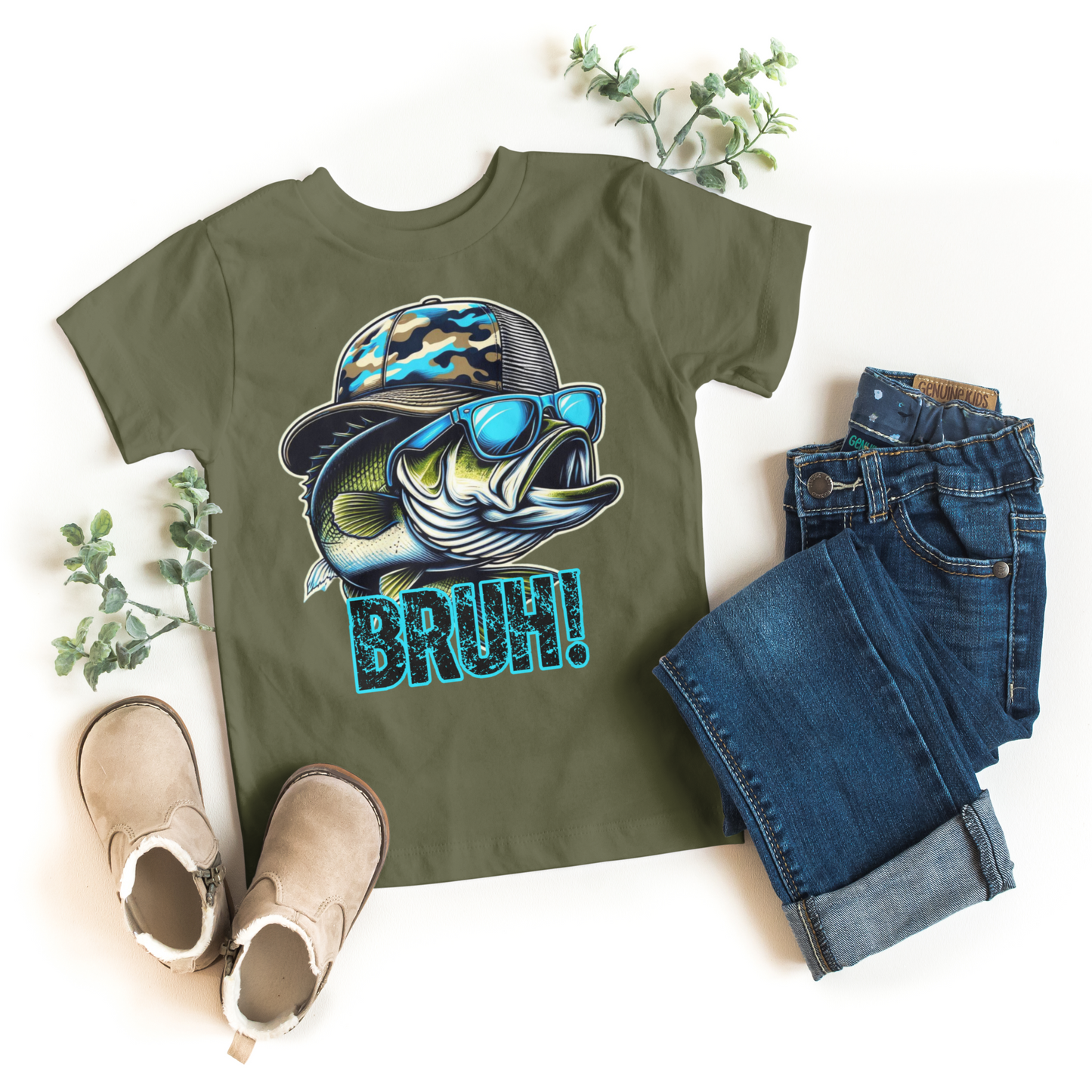Green t-shirt with fish graphic and 'BRUSH' text, paired with jeans and boots on a white background.