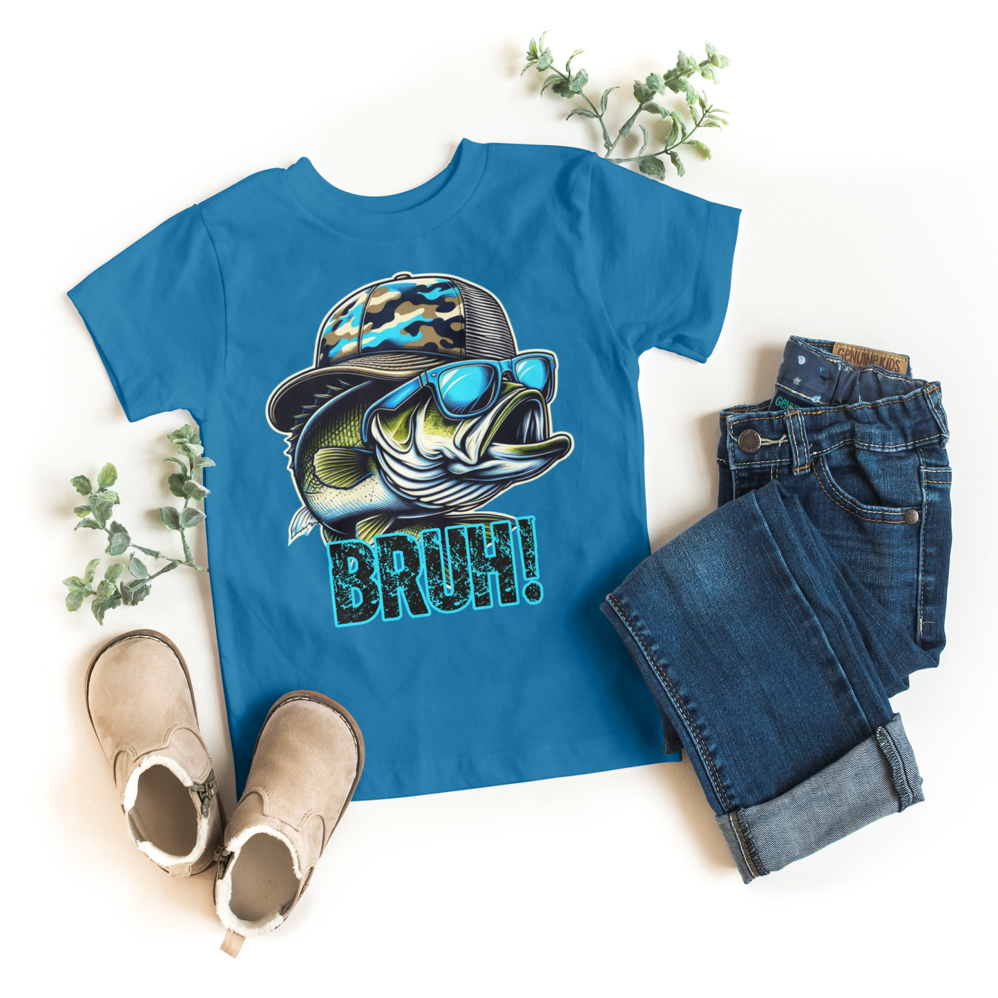 Blue t-shirt with fish graphic and 'BAH!' text, paired with jeans and boots on a white background.